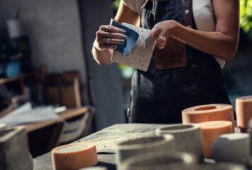 Close up of craftswoman hands making decorative concrete vase in her workshop.