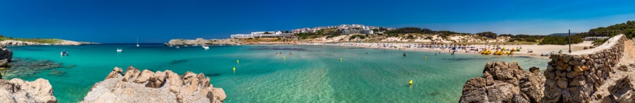 Spain, Balearic Islands, Menorca, Son Parc, Panorama of Platja Arenal den Castell bay in summer with town in background