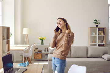 Girl feeling happy. Joyful young woman receives good news during pleasant conversation on mobile...