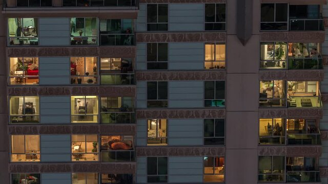 Windows in recidential building exterior in the late night with interior lights on timelapse