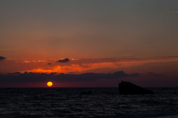 Fototapeta premium Sunset with huge sun falling on the sea at Aphrodite beach in Cyprus