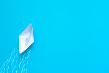 Paper boat on blue background