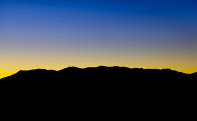Nice sunset captured between golden hour and blue hour. The mighty dense mountains block out the sun making those beautiful colors reflect in the clean sky.