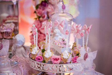 Delicious desserts at the wedding candy bar in the buffet area: cake pops decorated with angels and cameo and fresh rosebuds