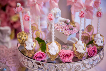 Delicious desserts at the wedding candy bar in the buffet area: cake pops decorated with angels and...