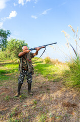 Vertical shot of a man with his rifle hunting in the Italian countryside of Calabria