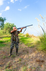 Fototapeta premium Vertical shot of a man with his rifle hunting in the Italian countryside of Calabria
