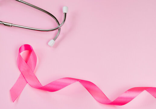 Pink ribbon and stethoscope on colored background. Breast Cancer Awareness Month. Women's health care concept. Symbol of fight against oncology.