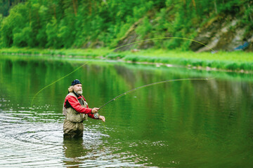 Fisherman fishing in the river. Fishing on the lake. Fly fishing.