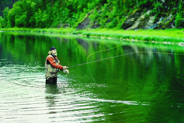 Fishing on the lake. A fisherman is fishing in the river. Fly fishing.