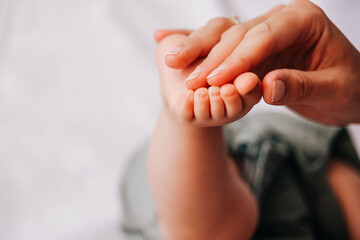 Closeup of mother holding baby hand fathers day