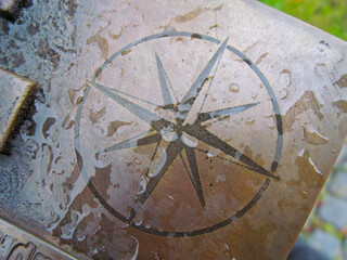 Sign of the wind rose on the monument in the park