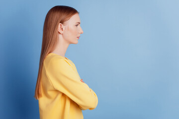 Profile portrait of pretty confident lady look empty space folded arms on blue background