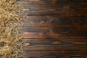 Dried hay on wooden background, flat lay. Space for text