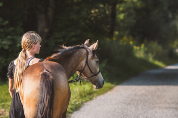 Mädchen geht mit Pferd spazieren