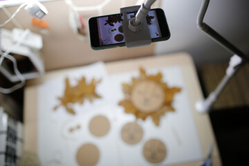 no name phone on a tripod takes pictures of a master class made of natural materials. Blogging and online master classes