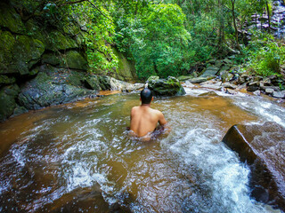 man in silence in natural waterfall in green forests from different angle