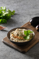 Baba ganoush of baked eggplant with parsley, garlic and olive oil. Vertical format. Close up. Middle Eastern cuisine, vegan hummus.