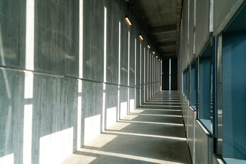 Long concrete corridor with vertical windows in a building