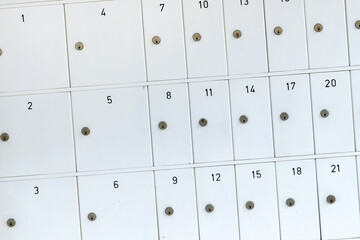 Textures of numbered gray mailboxes.