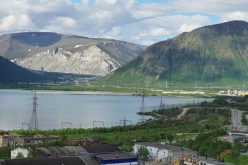  Russia, Murmansk region. Kirovsk. View of the industrial part of the city of Kirovsk on a summer day. Khibiny mountains Khirbiny and lake