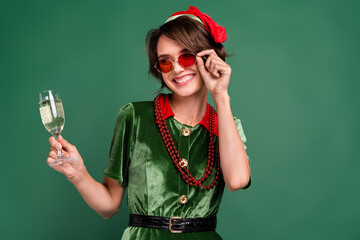 Photo of lady drink sparkling wine look empty space wear sunglass beads elf costume hat isolated...