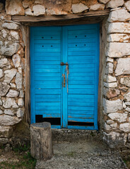 An old wooden blue door on a stone wall