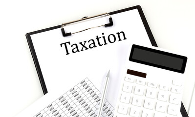 TAXATION text on folder with chart and calculator on the white background