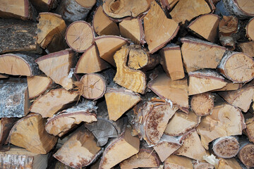 Fototapeta premium Stacked firewood made of birch and oak for stove heating of a village house with a fireplace.