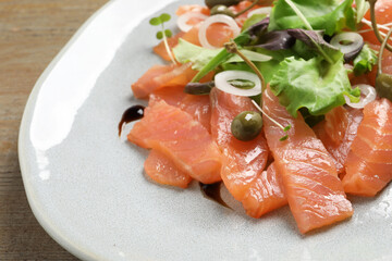 Delicious salmon carpaccio served on wooden table, closeup