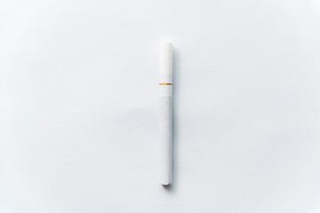 Single cigarette on white background. Copy Space. Close up.