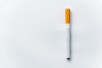 Single cigarette on white background. Copy Space. Close up.