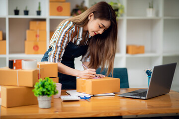Portrait of Asian young woman SME working with a box at home the workplace.start-up small business owner, small business entrepreneur SME or freelance business online and delivery concept.