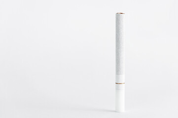 Single cigarette on white background. Copy Space. Close up.