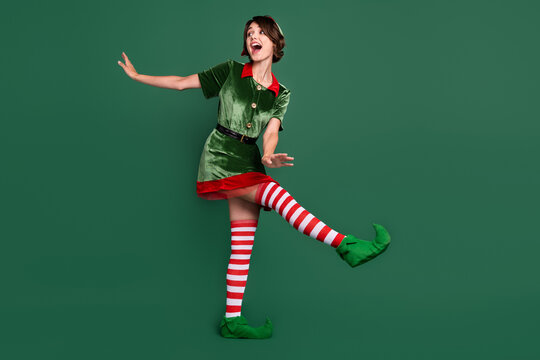 Full length body size view of attractive cheerful girl wearing elf look dancing isolated over green color background