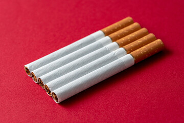 Five pieces of cigarettes evenly located on a red