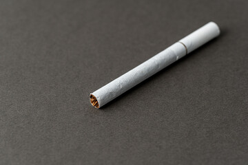 One cigarette on a gray background for a copy space.