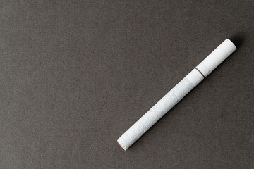 One cigarette on a gray background for a copy space.