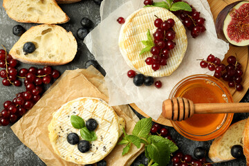 Concept of tasty food with grilled camembert on black smokey background