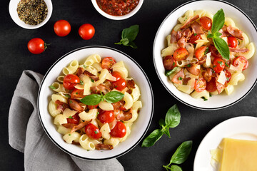 Pasta with bacon, tomato, parmesan cheese and basil leaves