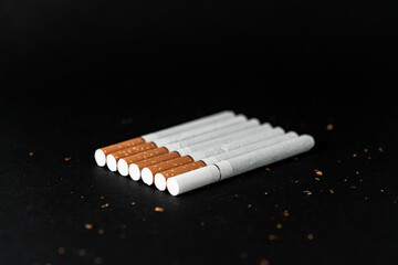 Seven cigarettes on a black background . Inserted in one