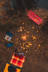 overhead top view of autumn camping site with tent car hammock bonfire