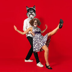 Contemporary art collage. Inspiration, idea, trendy urban magazine style. Young man and woman headed with dog's heads dancing isolated over red background