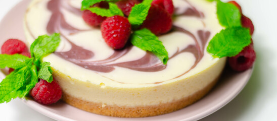 Creamy vanilla baked cheesecake, swirled with raspberry sauce on a biscuit crumb base