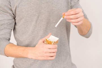 Hand will give a cigarette from a pack of cigarettes.