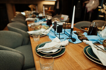 Beautifully laid tables with food, glasses and appliances in restaurant.