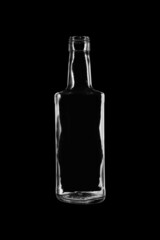 Empty, open bottle made of transparent, colorless glass for alcoholic beverages and other liquids. Isolated on a black background, close-up