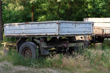 Fototapeta na wymiar abandoned rusty cargo trailer to the car on the street