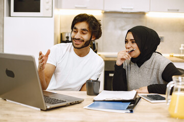 Arab students studying and learning at home with a laptop and notes