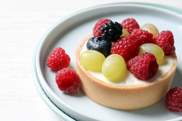 Delicious tartlet with berries on white table, closeup